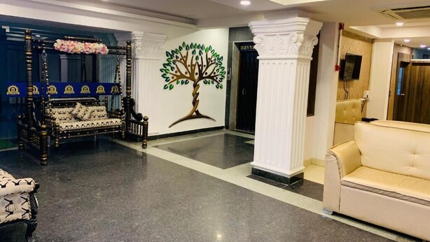 Eine Lobby mit einer Couch, einer Wandmalerei eines Baumes und einer Säule.