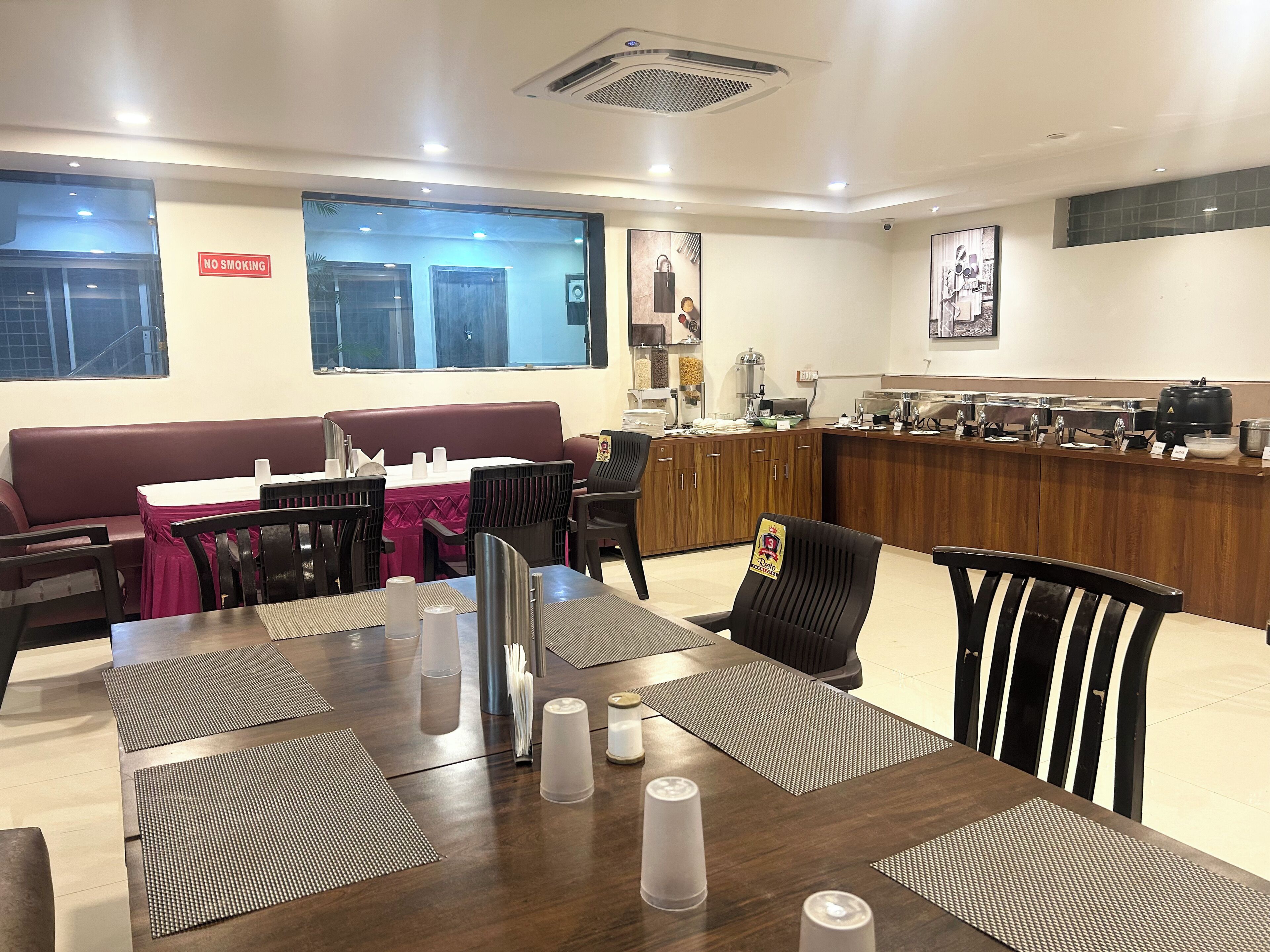 A restaurant with a booth seating area, a counter with food service, and a 'No Smoking' sign on the wall.