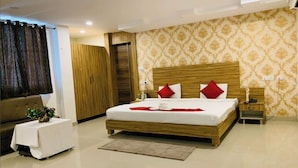 Ein modernes Hotelzimmer mit einem großen Bett, einem Holzkopfbrett und einem kleinen Nachttisch.