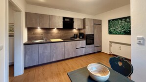 Una cucina moderna con mobili grigi, un forno nero e una macchina per il caffè.