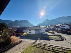 A residential area with houses, a paved road, and mountains in the background.