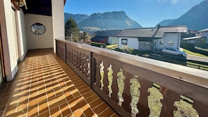 Un balcone con pavimento piastrellato e ringhiera in legno.