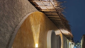 A corridor with curved walls, small windows, and a gravel path.