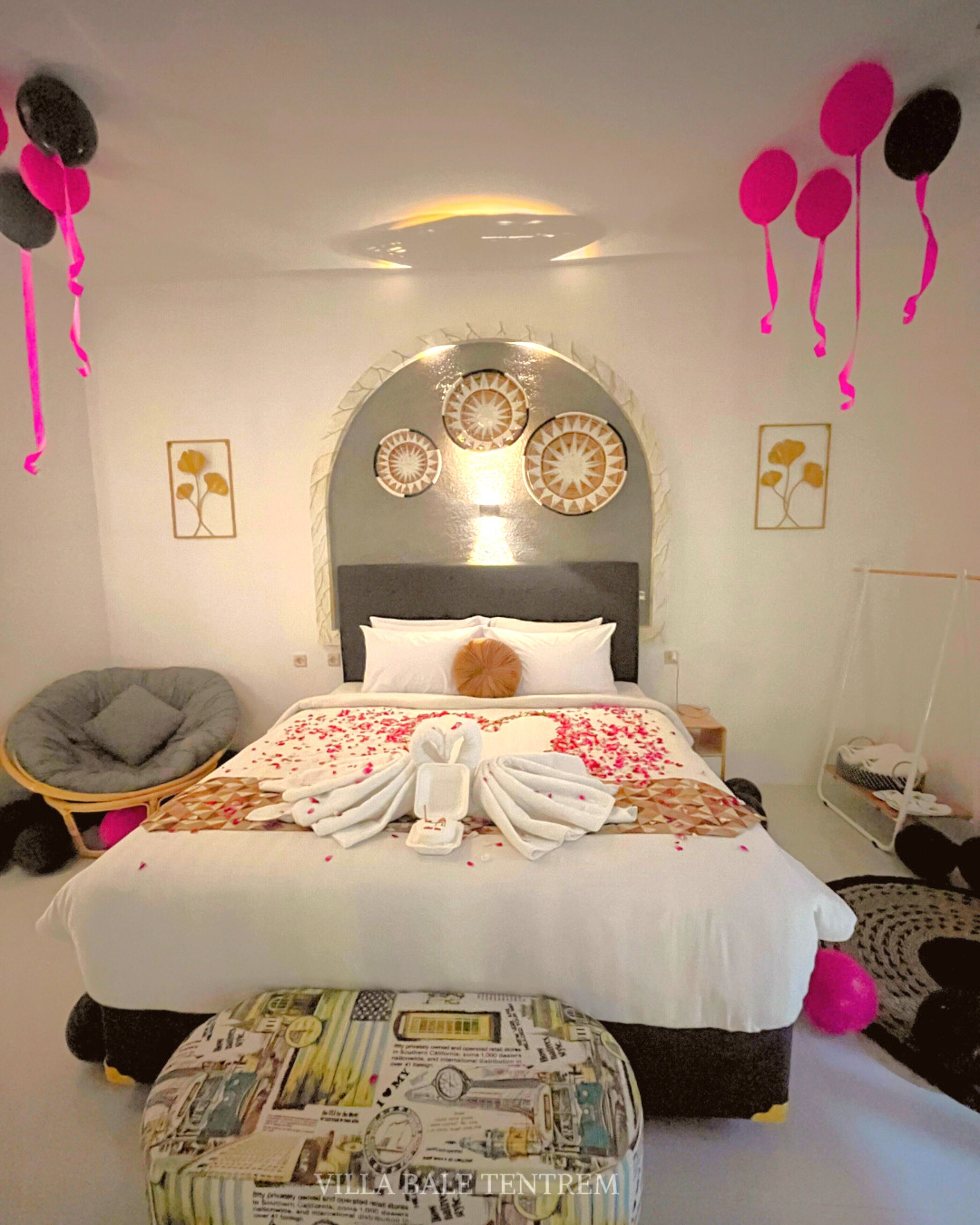 A bedroom with a bed, a round chair, a small table, and a wall-mounted shelf.