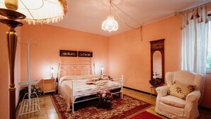 A bedroom with a bed, a chair, a nightstand, a lamp, and a mirror. - La Casa Dei Fiori-Oasis of peace in Fabrica di Roma (Lazio)