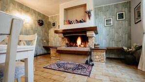 A cozy living room with a fireplace, a bookshelf, and a patterned rug. - La Casa Dei Fiori-Oasis of peace in Fabrica di Roma (Lazio)