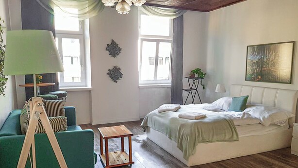 Een slaapkamer met een bed, bureau, stoel en lamp.