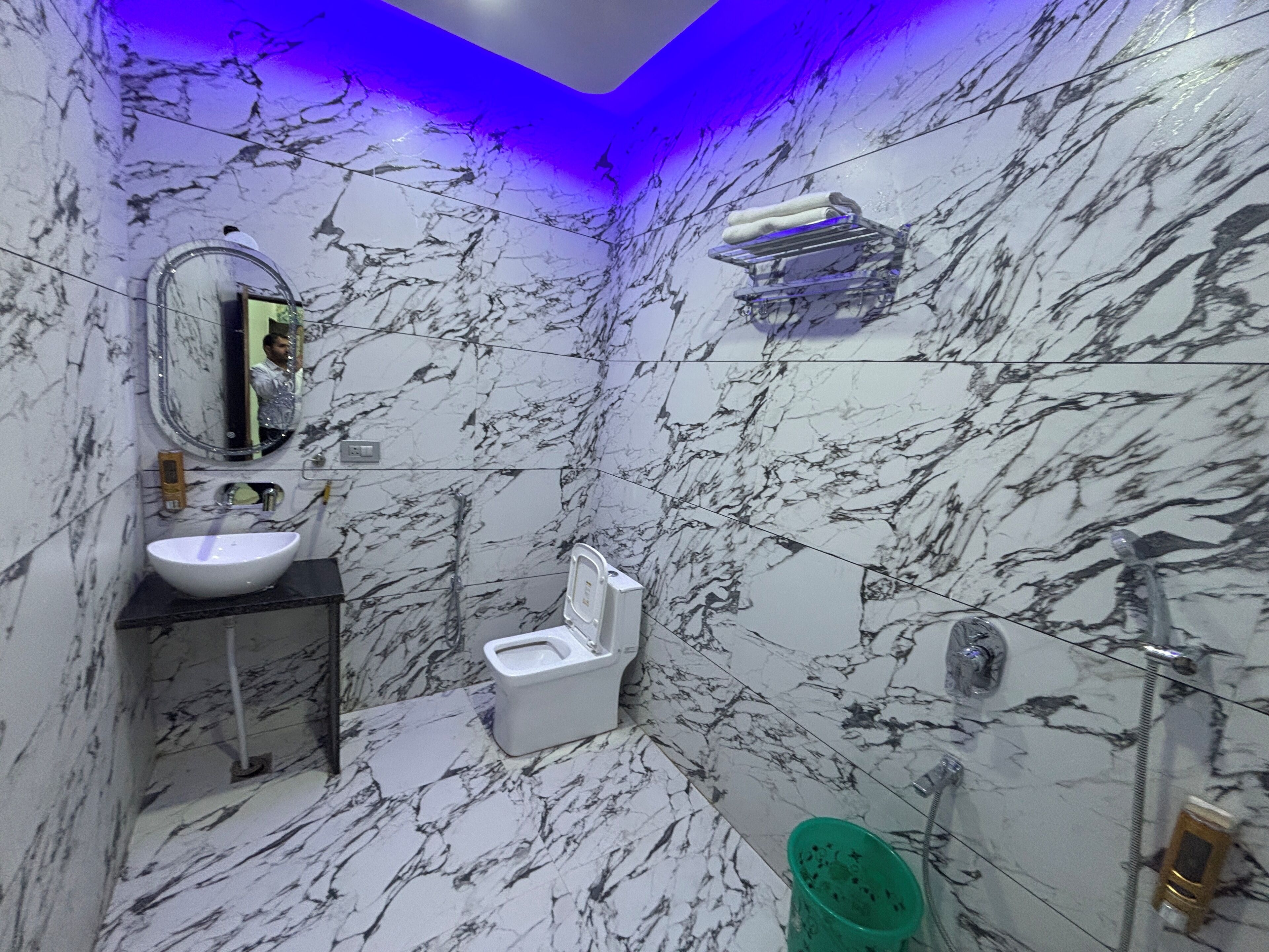 Une salle de bain avec un sol en marbre, un lavabo, des toilettes et un miroir.