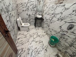 Un baño con inodoro, lavabo y zona de ducha.