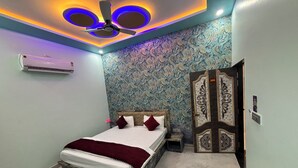A bedroom with a bed, a ceiling fan, and a decorative door. - Hotel GV Group and Restaurant (Khatoo)