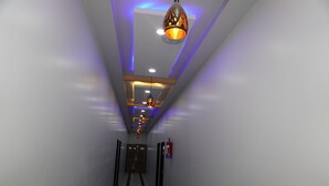 A hallway with a modern ceiling design, recessed lighting, and a decorative hanging light fixture. - Hotel GV Group and Restaurant (Khatoo)