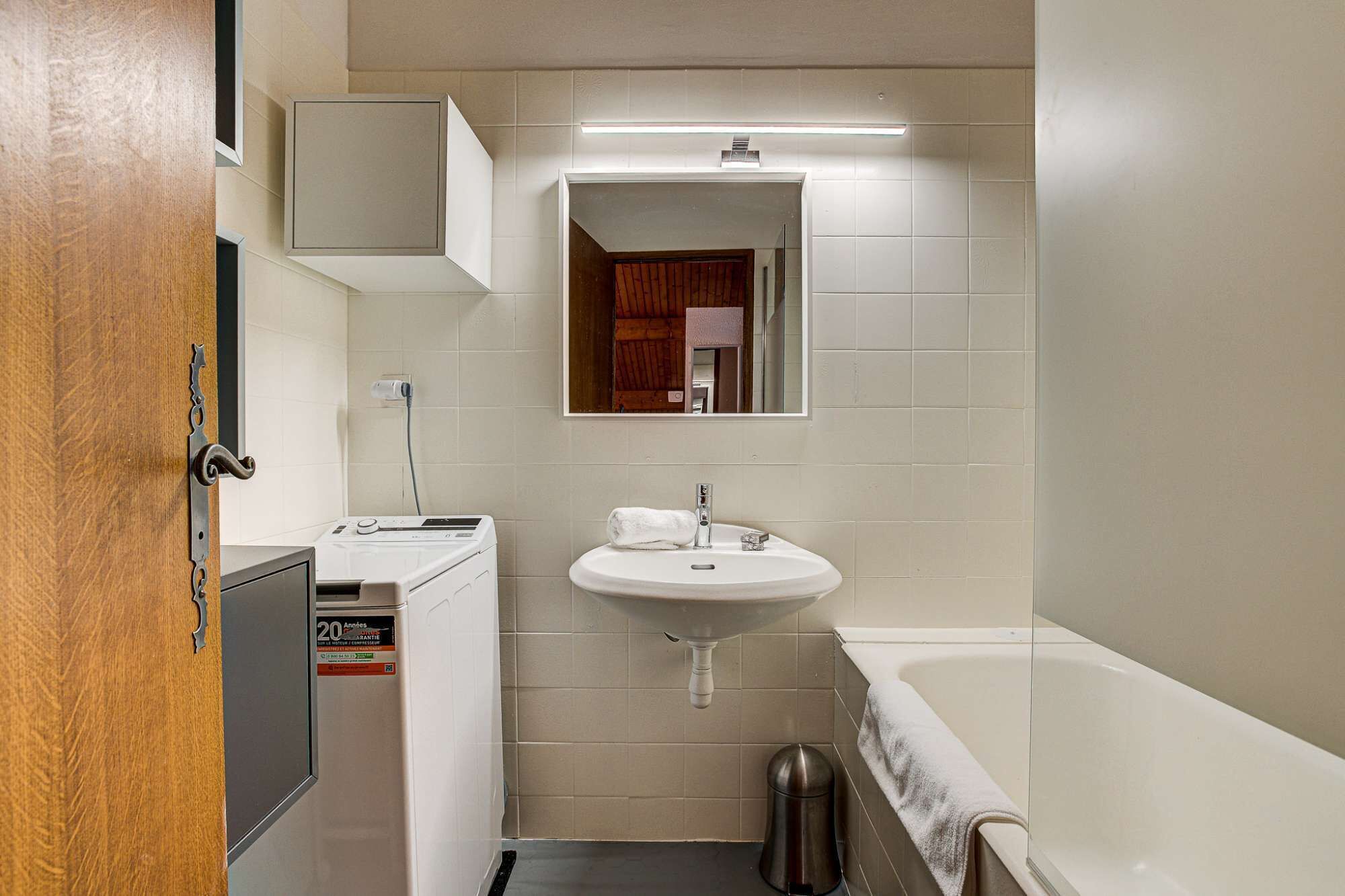 A compact bathroom with a white sink, a mirror, a toilet, and a bathtub.