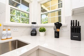 A modern kitchen with a built-in sink, a blender, a potted plant, and a knife block. - Spacious 4BR Home Mins to Santa Clara & Tech Campuses (San Jose)