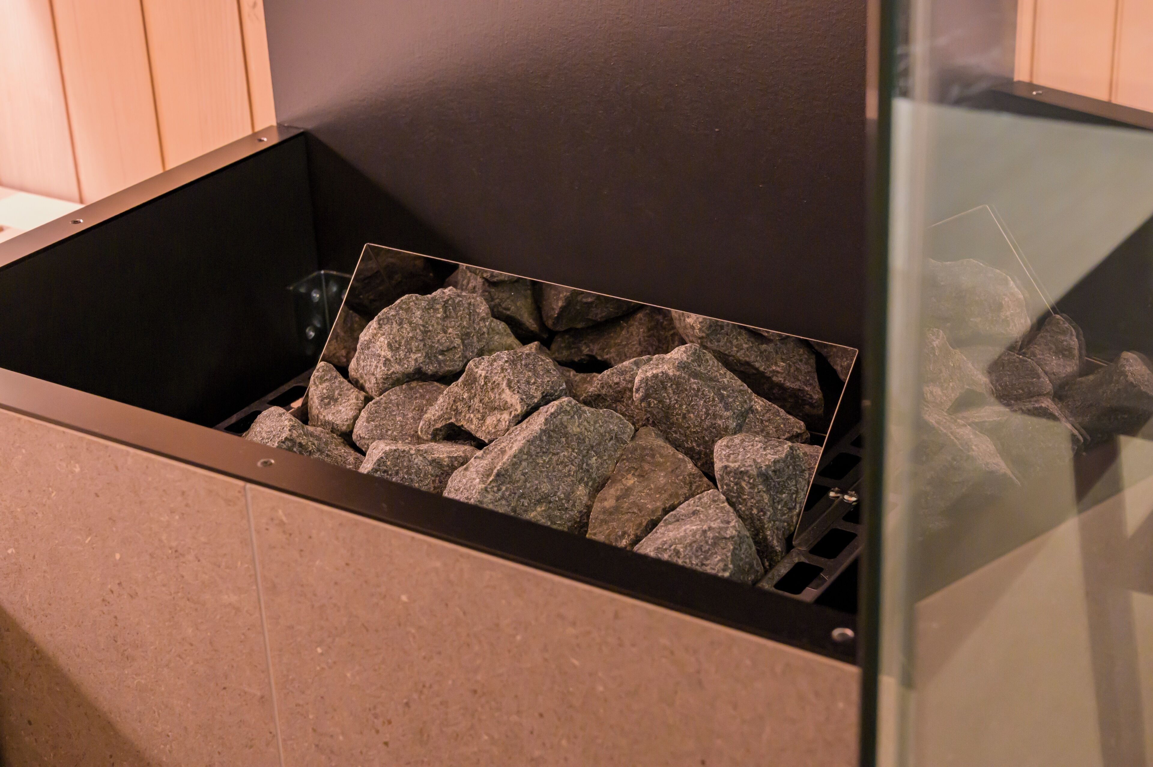 A fireplace with a stone surround and a glass enclosure.