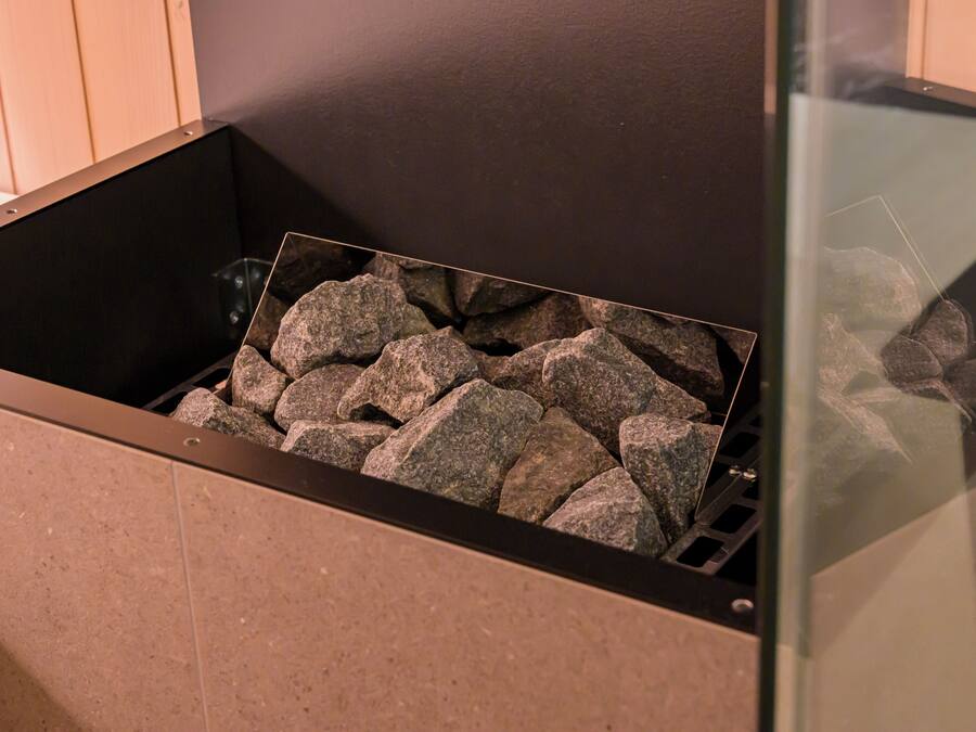 A fireplace with a stone surround and a glass enclosure.