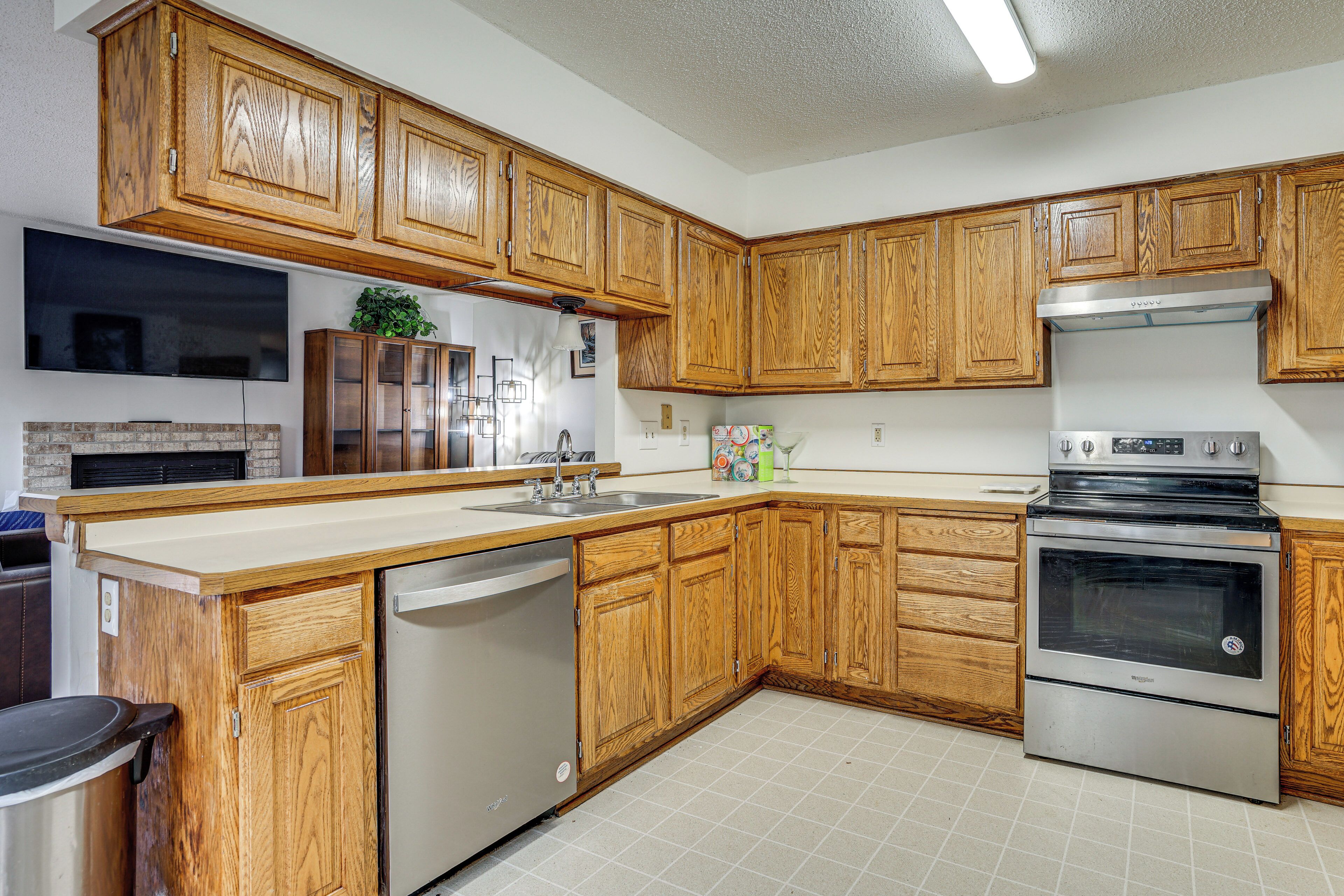 A kitchen with wooden cabinets, a stainless steel dishwasher, and a built-in oven.