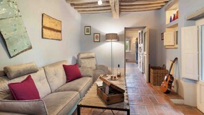 Una sala de estar acogedora con un sofá, una mesa de centro, una lámpara y una guitarra.