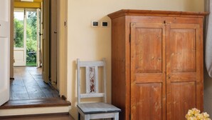 Una habitación con una escalera de madera, un armario de madera, una pequeña mesa con una bandeja de comida y una silla.