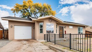 A single-story house with a garage, a fenced yard, and a tree with yellow leaves. - Hike & Golf: Farmington Home 1 Mi to Animas River! (Farmington)