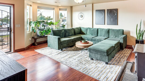 A modern living room with a sectional sofa, a coffee table, and a ceiling fan. - Hike & Golf: Farmington Home 1 Mi to Animas River! (Farmington)