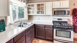 A kitchen with a sink, stove, and microwave. There are cabinets above the sink and a window with curtains. - Hike & Golf: Farmington Home 1 Mi to Animas River! (Farmington)