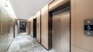 Een moderne lift met bedieningspaneel en een marmeren vloer.