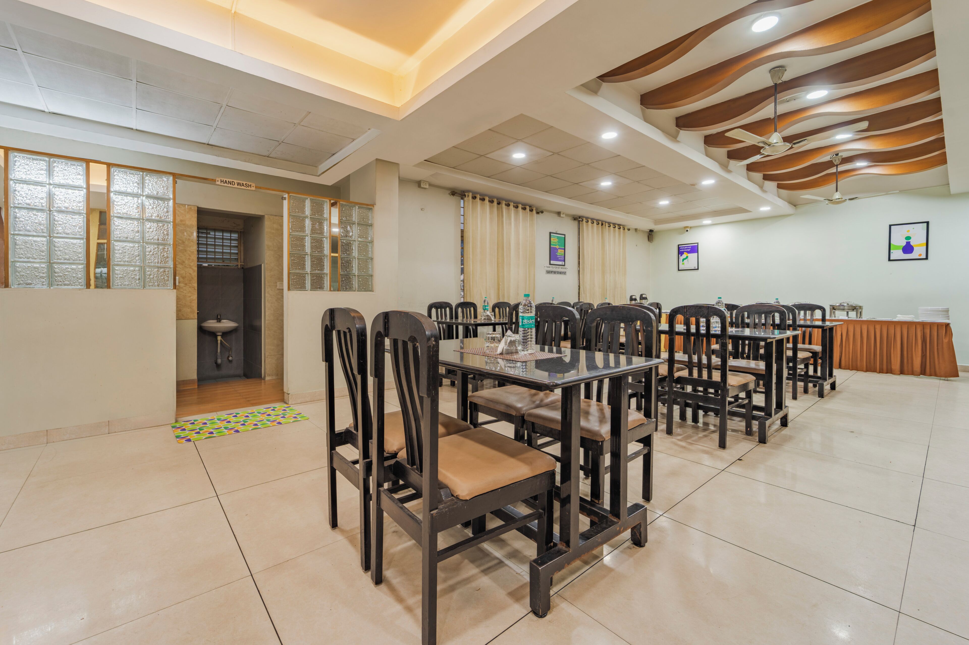 A conference room with a long table, chairs, and a hand wash station.