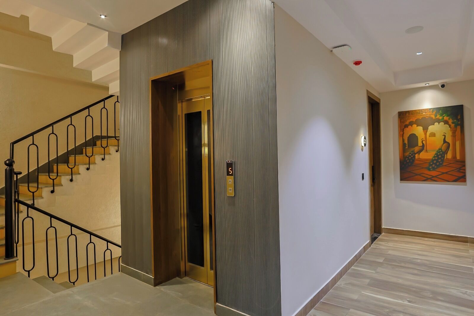 A modern interior with a staircase, an elevator, and a wall-mounted artwork.