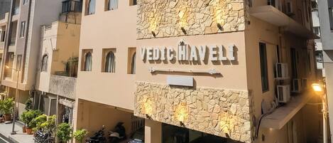 A multi-story building with a stone facade and the name "VEDICHIAVELLI" on the front.