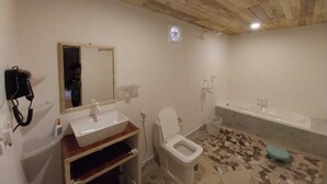 Ein Badezimmer mit Holzboden, einem Waschbecken, einer Toilette und einer Badewanne.