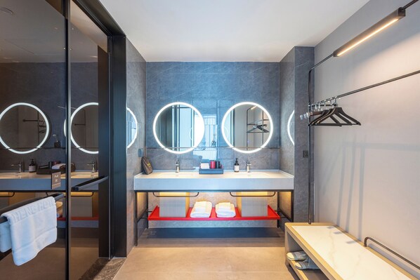 A modern bathroom with two sinks, round mirrors, and a towel rack. - ECHENG Hotel (Luoyang)