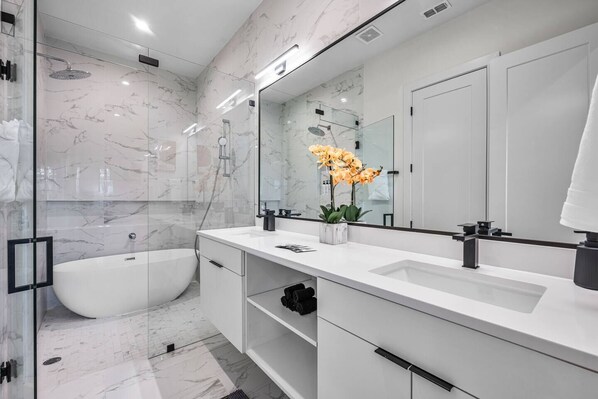 Une salle de bain moderne avec une baignoire sur pieds, un grand miroir et une cabine de douche.