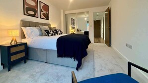 Ein modernes Schlafzimmer mit einem Bett, Nachttischen und Kunstwerken an der Wand.