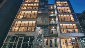 A modern building with multiple floors, large windows, and a staircase leading to the entrance. - illi Nuto Shinjuku (Tokyo)