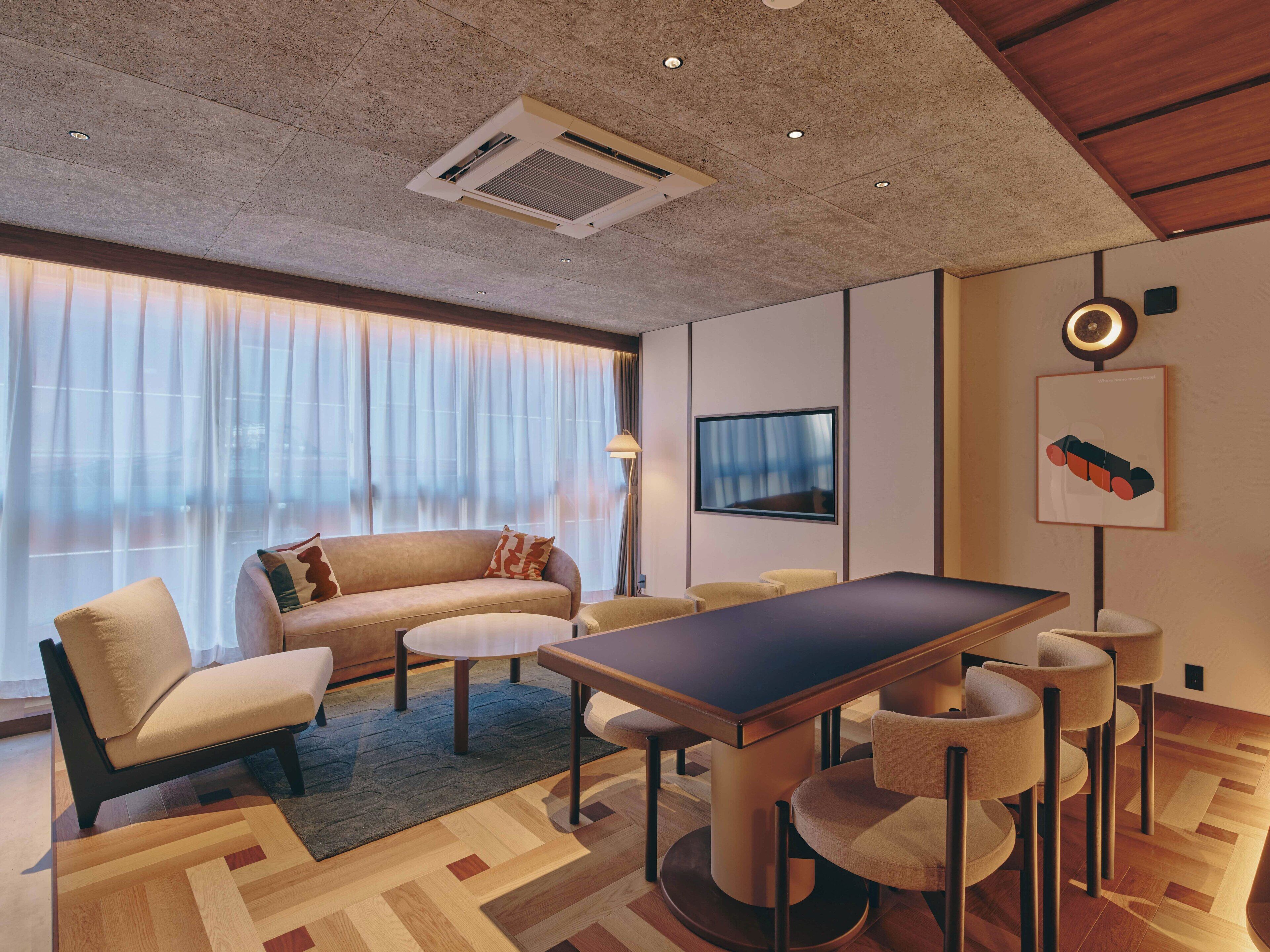 A modern living room with a sofa, coffee table, and dining table.