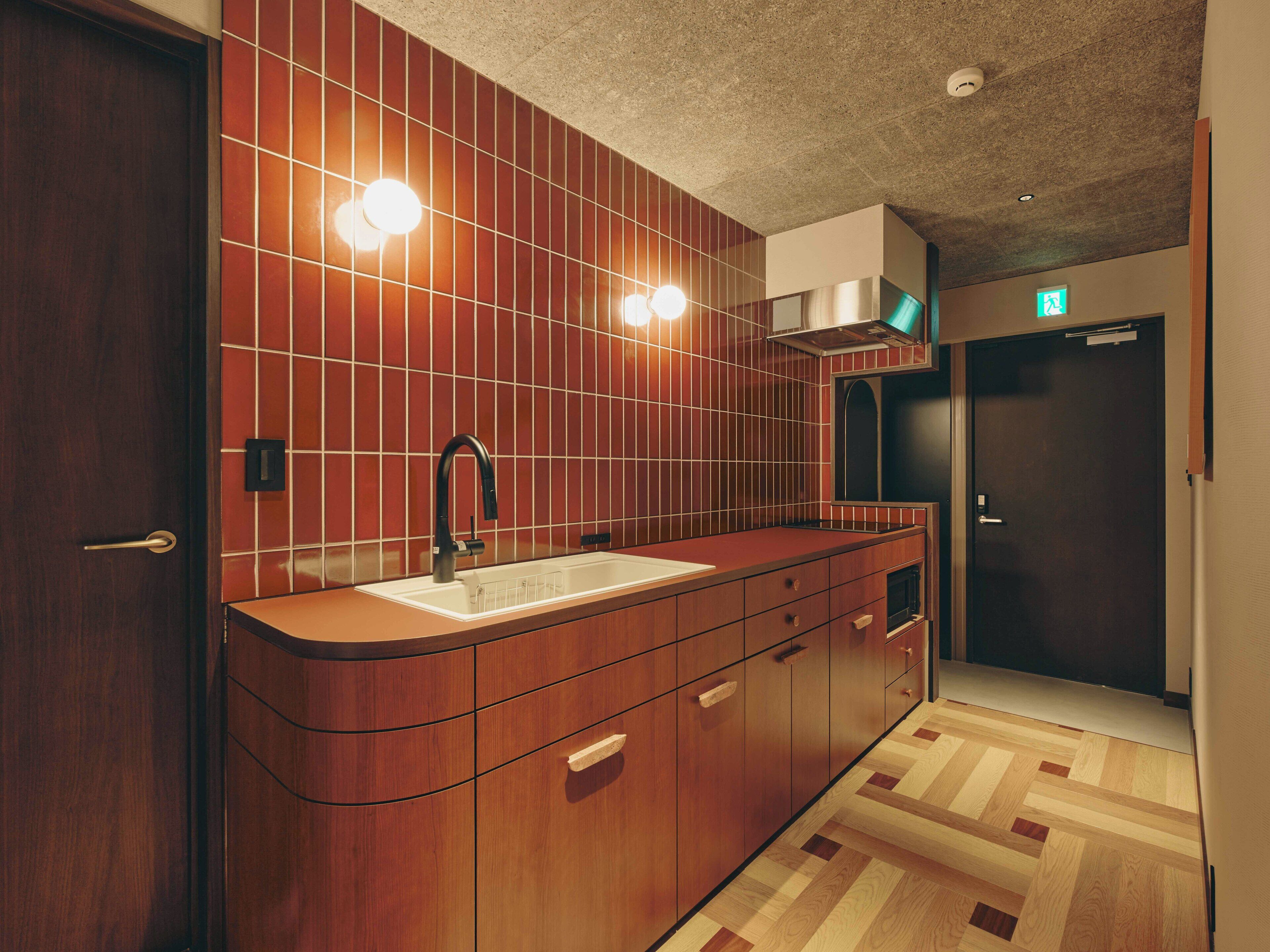 A modern bathroom with a wooden vanity, a sink, and a mirror. There is a towel rack above the sink and a shower area visible in the background.