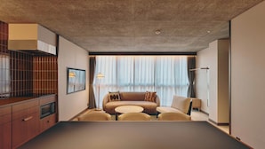A modern hotel room with a dining table, sofa, and a large window with curtains. - illi Nuto Shinjuku (Tokyo)