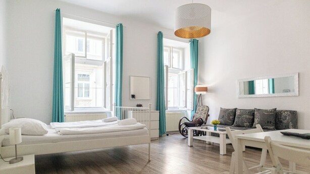 Ett modernt hotellrum med en säng, ett matbord och en soffa.