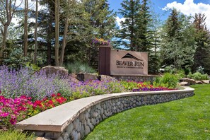 Schild für Beaver Run Resort & Conference Center, umgeben von einem angelegten Garten mit verschiedenen Blumen und einer Steinmauer.