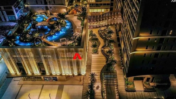 Een hotel met een zwembad op het dak, een overdekt buitengebied en een moderne gevel.