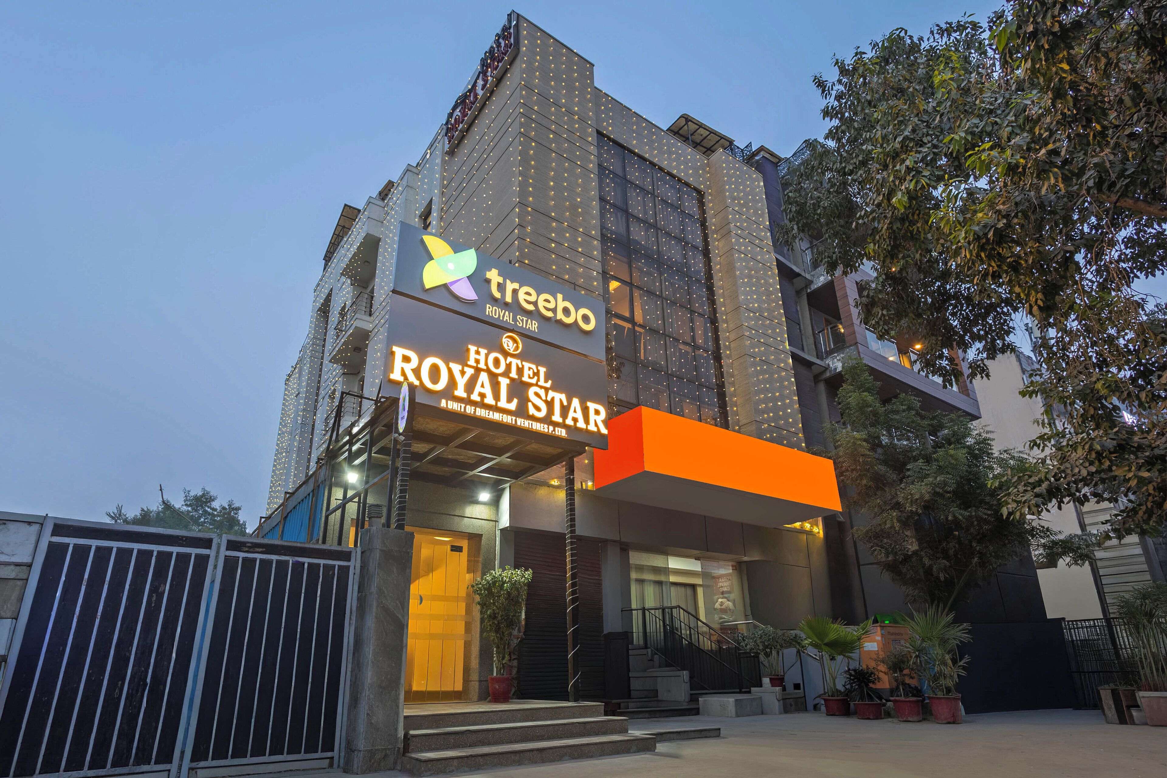 Een hotel genaamd 'Treebo Royal Star' met een moderne gevel, grote ramen en een opvallende ingang.
