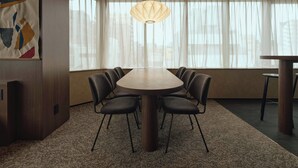 A modern dining room with a round table, six chairs, a hanging light fixture, and large windows with sheer curtains. - illi Haku Asakusa (Tokyo)