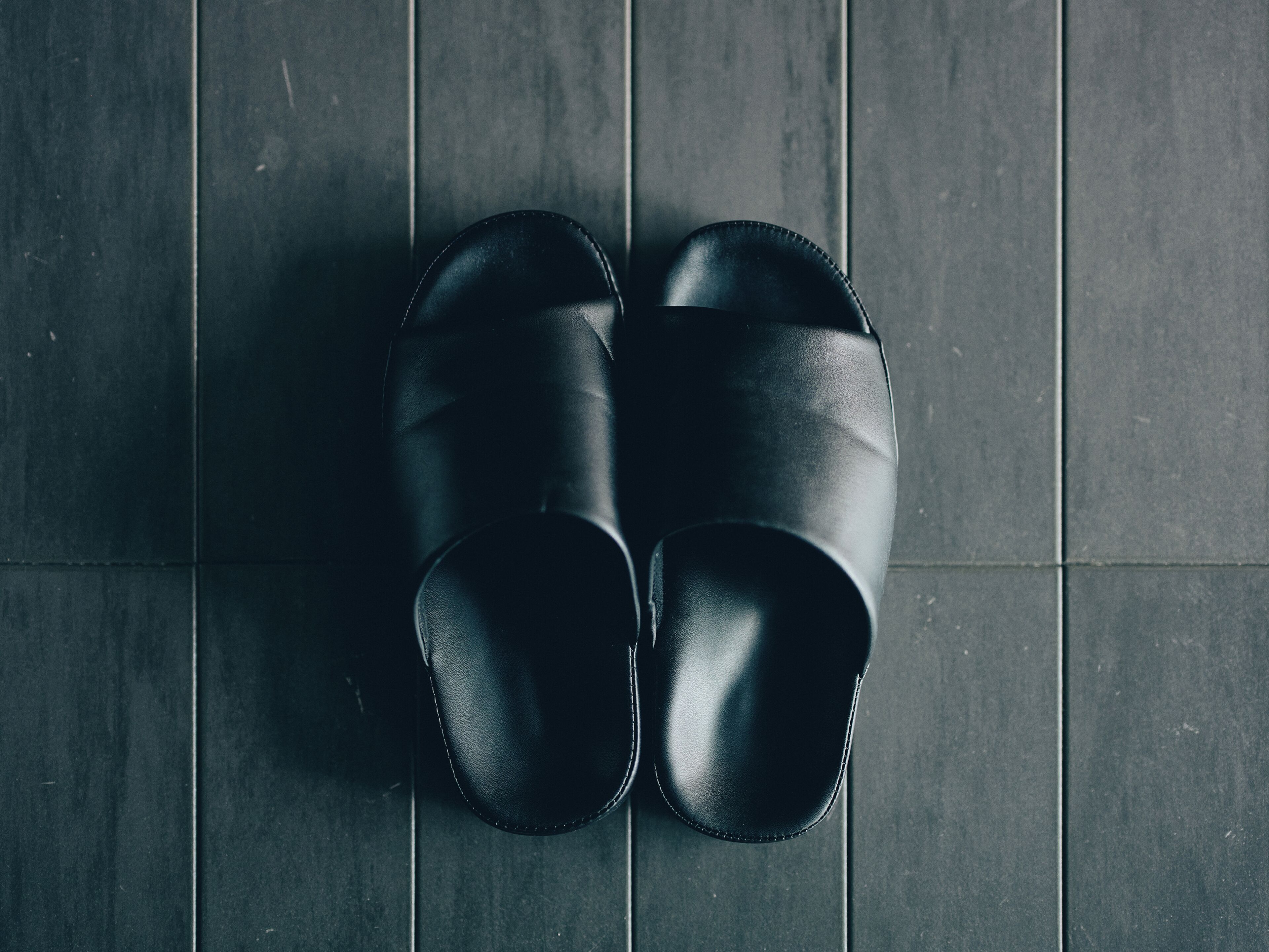 Une paire de chaussures noires sur un sol carrelé.