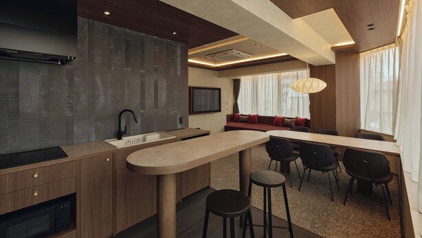 A modern kitchen with a built-in stove, a sink, and a dining area with a high table and chairs. - illi Haku Asakusa (Tokyo)