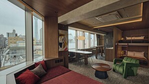 A modern hotel room with a large window, a sofa, a dining area, and a bunk bed. - illi Haku Asakusa (Tokyo)