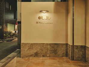 A hotel entrance with a marble floor, a light fixture above the entrance, and the name 'Hako Asakusa' engraved on the wall. - illi Haku Asakusa (Tokyo)