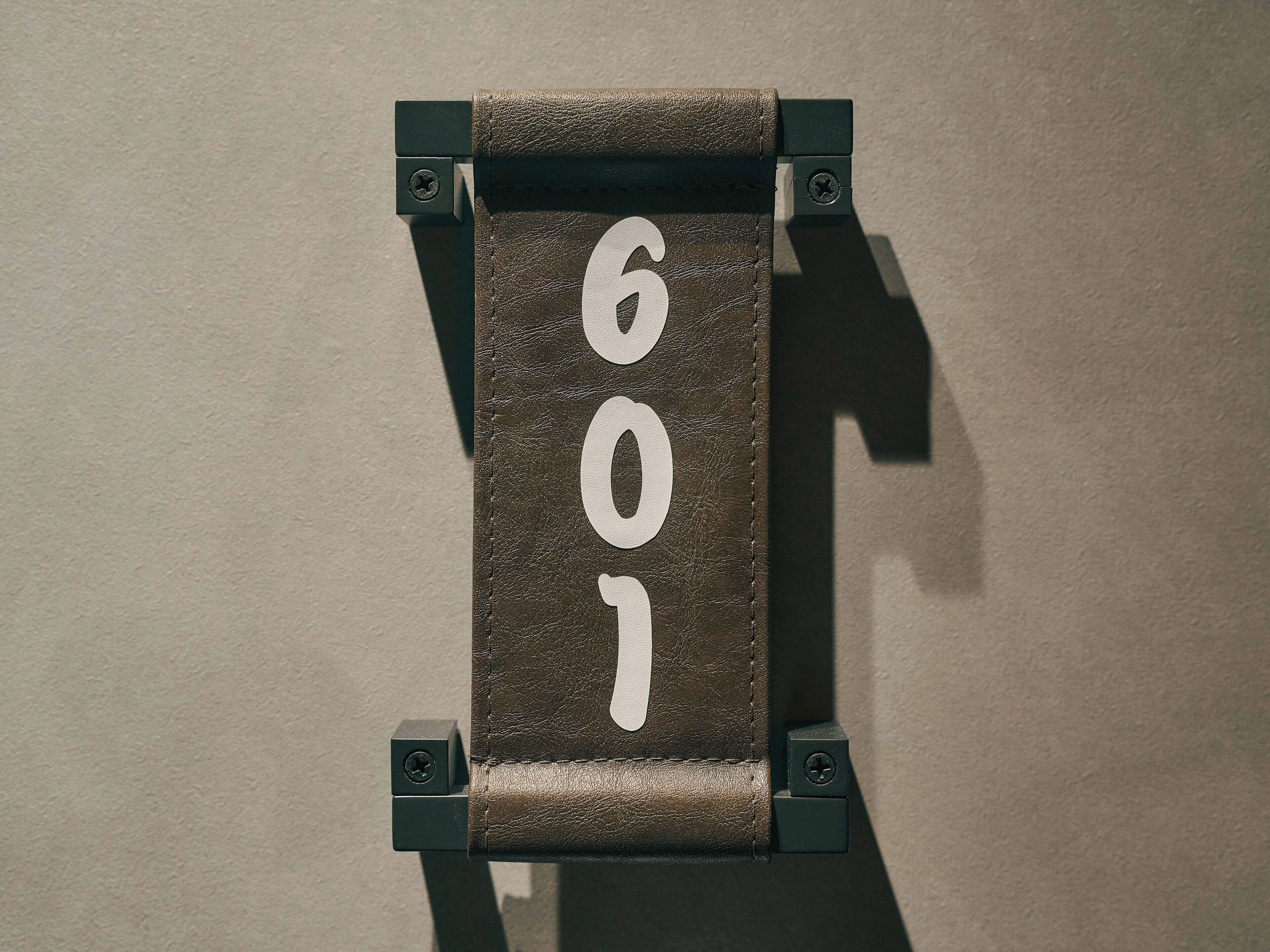 Une plaque fixée au mur, portant le numéro « 601 ».
