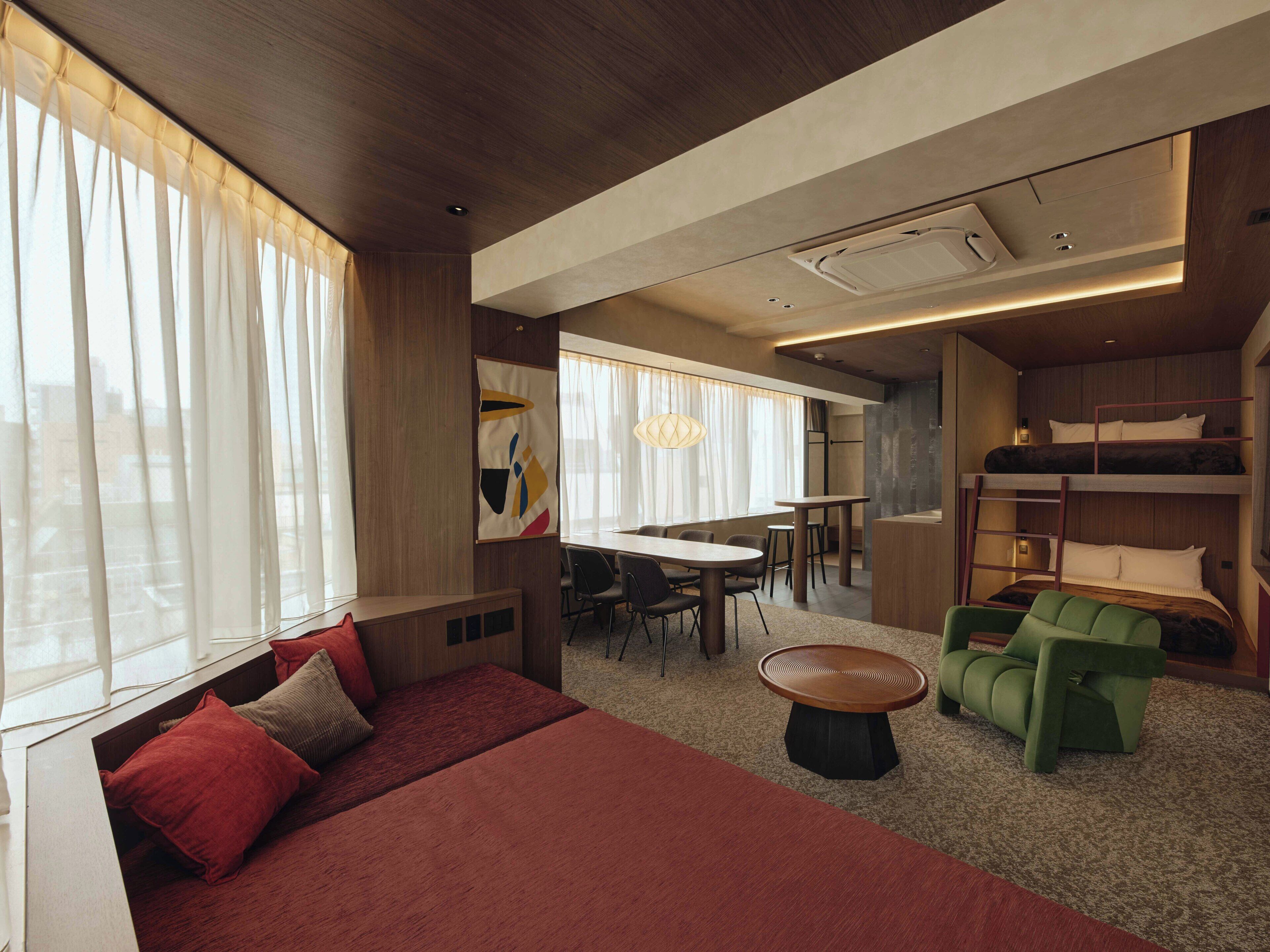 A modern interior with a sofa, dining table, chairs, and a bunk bed.