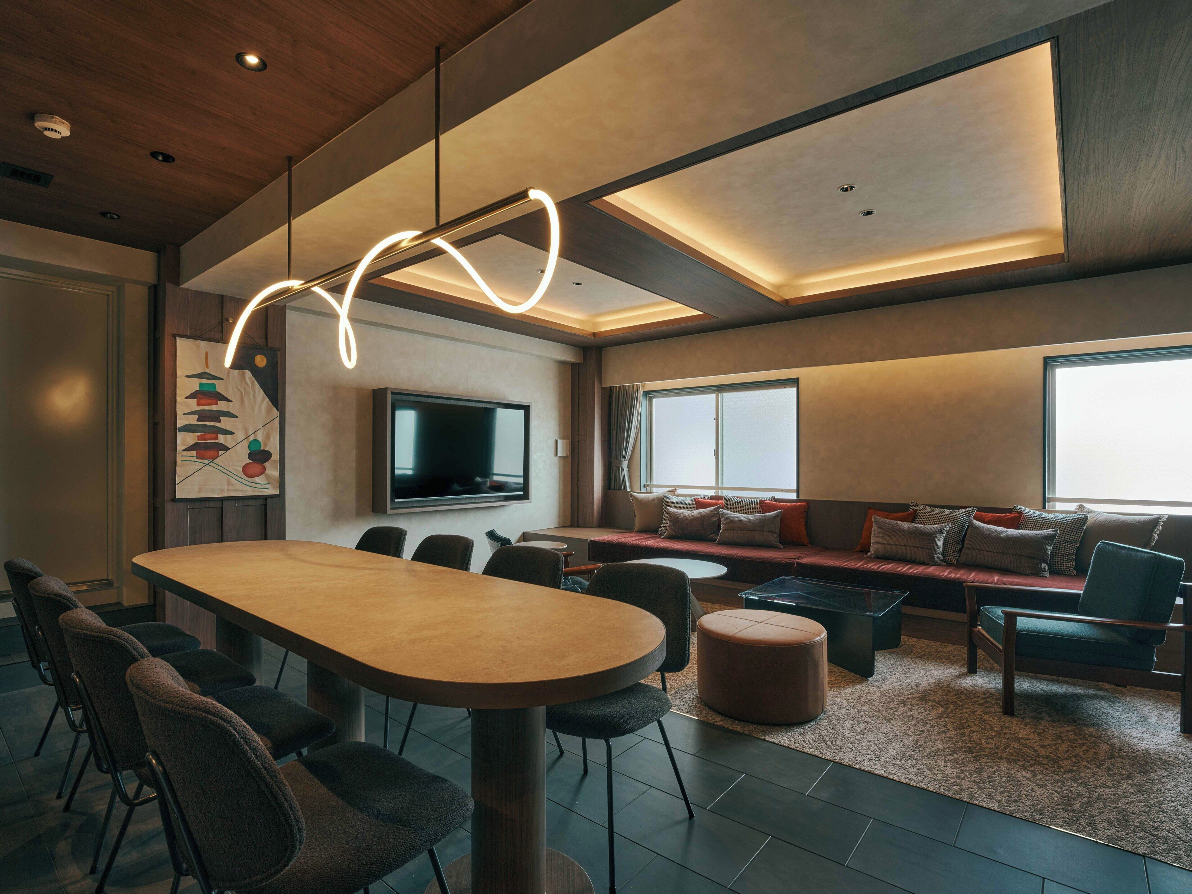 Un interior moderno con comedor, asientos y televisor.
