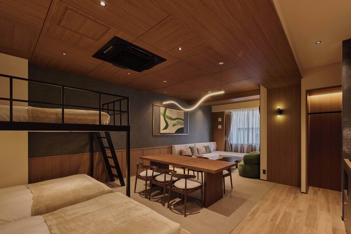 A modern interior with a bunk bed, a dining area, and a sofa.
